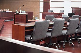 A courtroom with chairs and a table in the foreground.